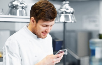 Chef qui regarde son téléphone en cuisine